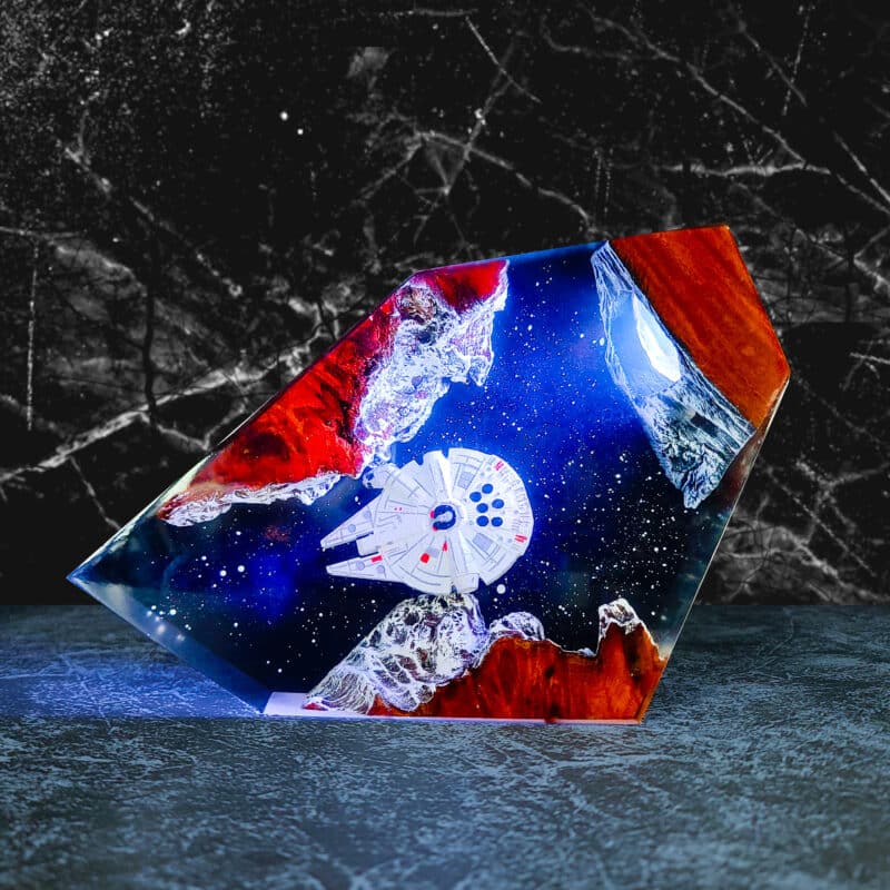 A stunning Millennium Falcon Resin Lamp, handcrafted with intricate details and glowing LED lights, serving as perfect Star Wars desk decor.