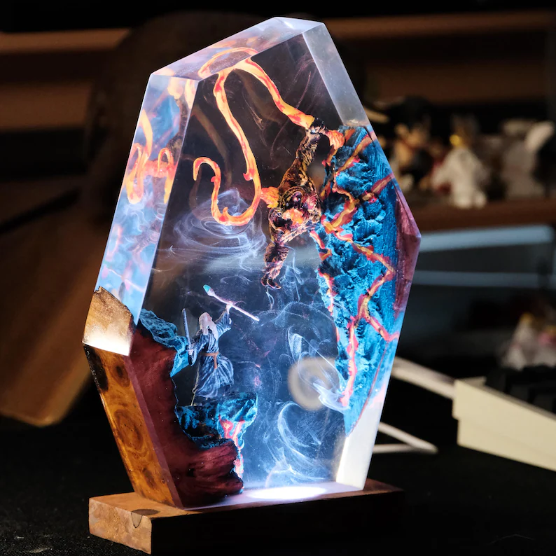 Close-up of a detailed Gandalf and Balrog resin lamp, illuminated, showcasing the epic battle scene. Ideal Lord of the Rings collectible and fantasy decor.